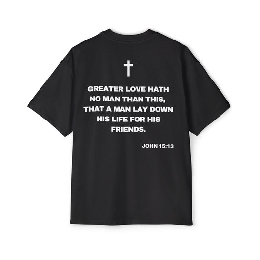 Back of Surrendered Apparel black oversized Christian T-shirt featuring the Bible verse John 15:13 in bold text, cross on top, providing a cozy fit perfect for cooler days and sharing faith