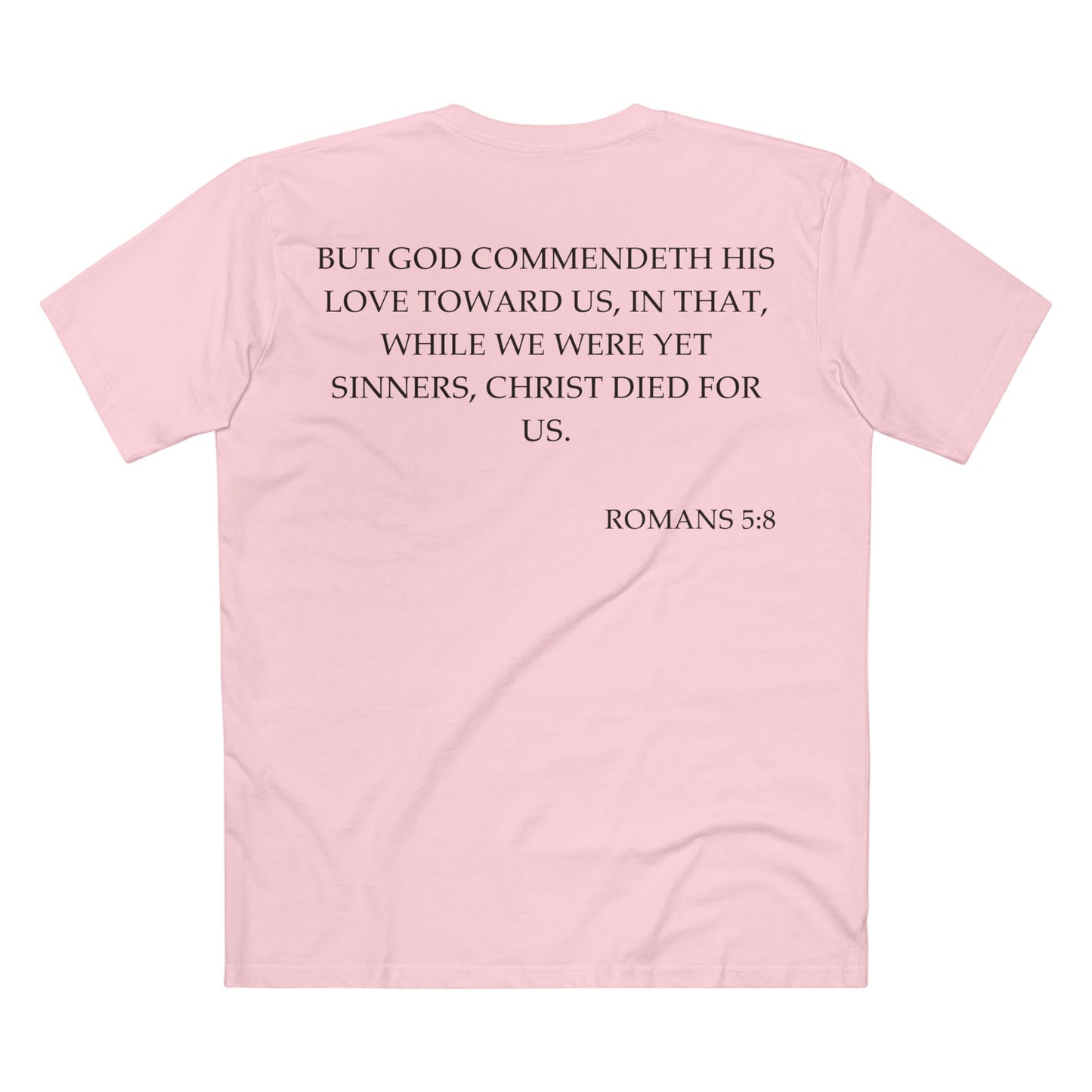 Back of Surrendered Apparel pink Christian T-shirt featuring the Bible verse Romans 5:8 in bold text, perfect for sharing faith and Jesus